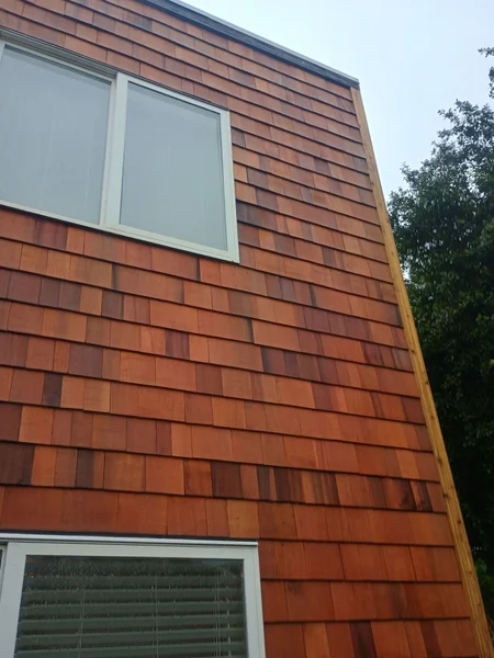 Exterior view of house with cedar shingle siding and white-framed windows